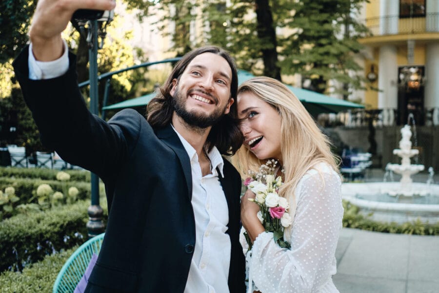 beautiful romantic newlyweds happily taking selfie HK6Z3F7