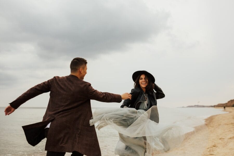 happy young couple have fun on the beach young attractive happy man and stylish woman in blue dress t20 6YwGAv