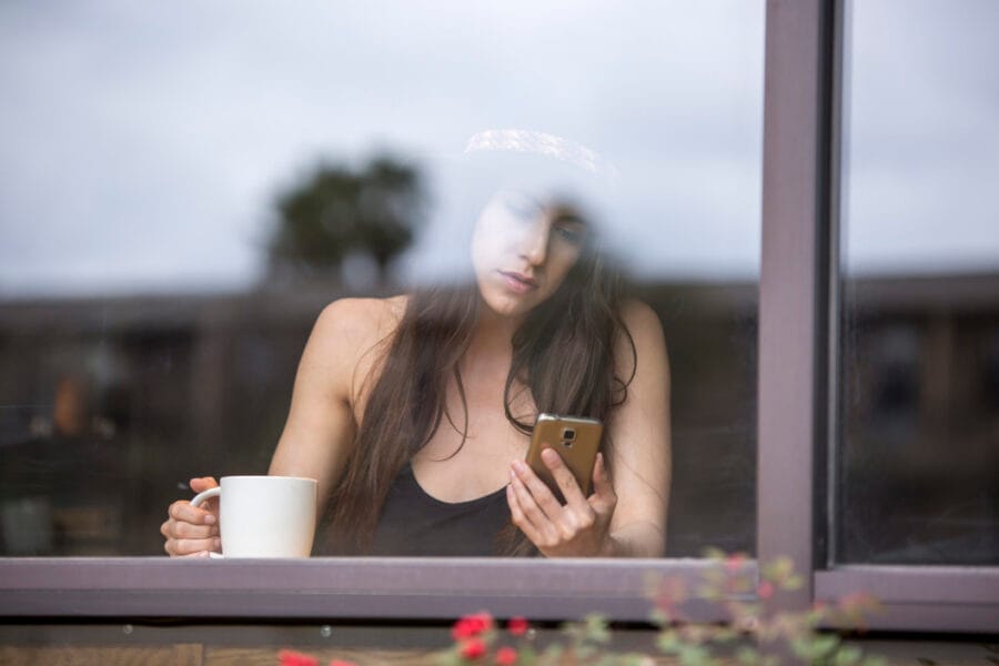 image of a happy beautiful attractive woman reading a text message on her smartphone in a coffee t20 g8alWz