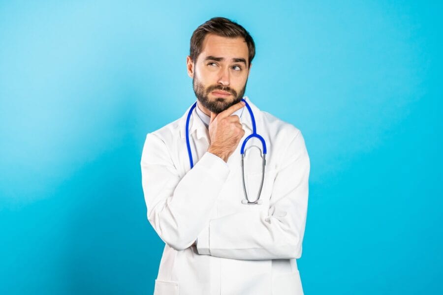 thinking doctor man looking up and around on blue background worried contemplative face expressions t20 N0mjAB