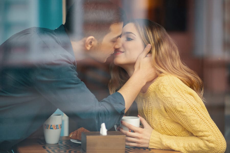 young attractive couple on date in coffee shop kis WNGP9B8
